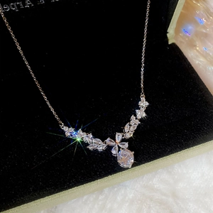 Macro shot of silver zircon floral pendant necklace inside a black velvet jewelry box