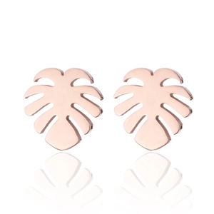 Macro shot of rose gold Monstera leaf earrings with hollow design on white background