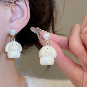 Detail showing soft white flocked rabbit stud earrings with elegant faux pearl accents