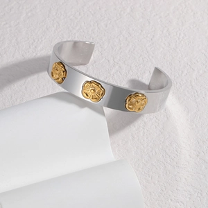 Silver C-shape stainless steel cuff bracelet with three golden embossed flower patterns