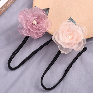 Detail shot of two elegant fabric flower bun makers in purple and pink tones.