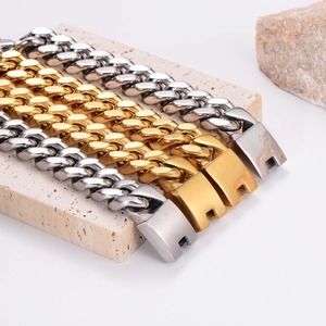 Mens 18K gold and silver stainless steel Cuban link bracelets on stone display