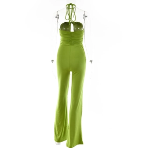 Detail view of green backless halter jumpsuit featuring waist ruching and flared leg cut