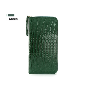 Primer plano de la textura de cocodrilo verde oscuro en la cartera larga con cremallera