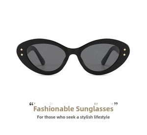 Detail of oval sunglasses showing gold star studs on black frames and dark lenses