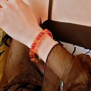 Macro detail of hand-woven vintage tiger eye and red agate double-strand beaded bracelet