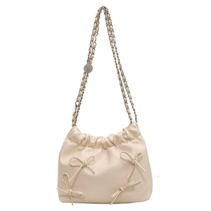 Creamy white bucket bag with bow accents and silver chain strap on white background