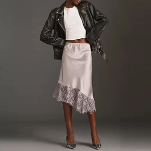 Close-up of silver satin skirt with exquisite lace trim and irregular hemline details