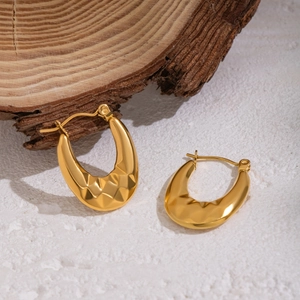 Detail of 18K gold-plated U-shaped earrings with geometric diamond pattern on stone base