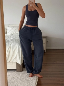 Detailed selfie of dark blue sports camisole paired with dark gray jogger pants in a bedroom