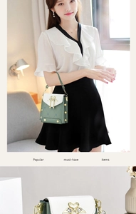 Detail of green and white quilted shoulder bag with golden swan heart clasp and rivets