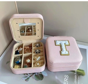 Pink PU leather jewelry box with mirror, rings slots, and white plush letter T patch