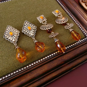 Detailed shot of vintage silver geometric earrings featuring amber stones and teardrop charms