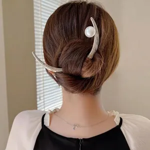 Elegant silver crescent moon hair stick with pearl detail shown in a stylish updo