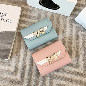 Short tri-fold women's leather wallet with metallic bow, light blue and pink colors