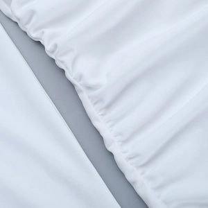 Close-up of the intricate ruched texture and gathered detail on white long sleeve dress