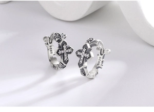 Macro shot of S925 sterling silver hoop earrings with vintage cross and white zircon stones
