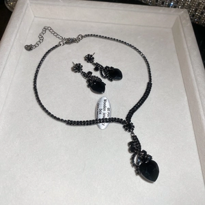 Detail shot of black heart pendant necklace and earrings set with dark rhinestones