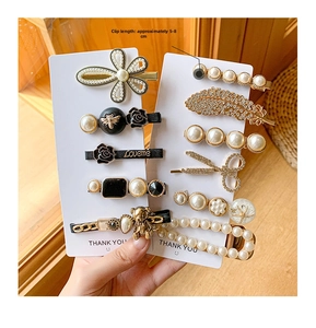 Detail of assorted pearl hair clips and gold bear pins on display cards, size 5-8cm