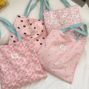 Close-up of pink canvas shoulder bags with sweet cartoon floral and animal patterns