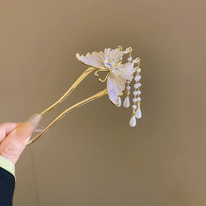 Detailaufnahme einer goldenen Schmetterlings-Haarnadel mit schillernden Perlenfransen