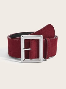 Détail de la large ceinture en daim bordeaux avec une boucle carrée en métal argenté