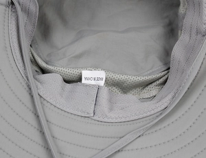 Detail view of the breathable mesh lining and adjustable chin strap of a sun hat