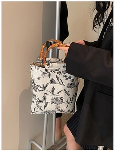 Chic jacquard canvas tote featuring natural bamboo handles and black floral patterns