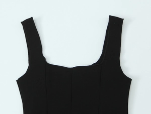Dettaglio dello scollo quadrato e delle spalline larghe di un crop top nero da donna
