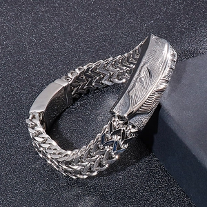 Macro view of men's hip hop steel bracelet with feather charm and braided chain