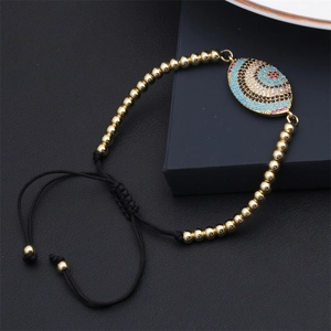 Detail of evil eye slider bracelet with colorful zircons on black jewelry box