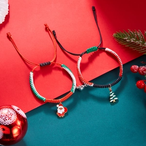 Detail of Christmas magnetic couple bracelets with Santa and tree charms on festive background