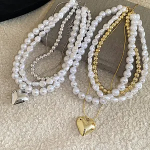 Collier de perles élégant avec grand pendentif cœur sur fond de texture douce