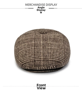 Detail view of brown plaid flat cap showing thick wool tweed texture and retro pattern