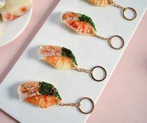Gros plan détaillé de porte-clés sushi saumon réalistes sur une assiette en céramique