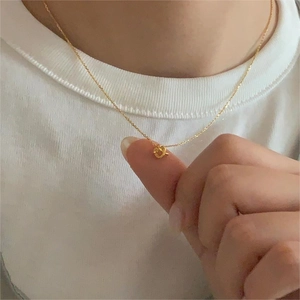 Minimalist 925 sterling silver heart knot necklace with gold finish shown on model
