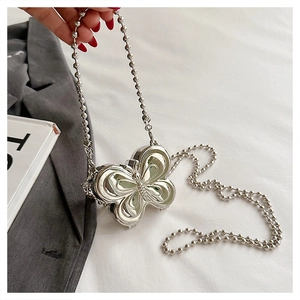 Detailed close-up of a silver butterfly shaped metal chain bag held against a white fabric