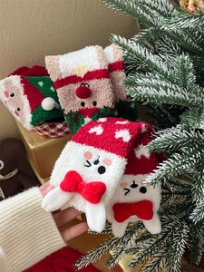 Close-up of thick coral fleece Christmas socks with festive red bows and holiday embroidery