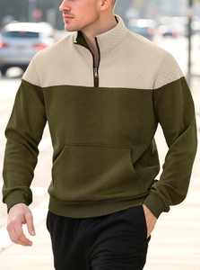 Detail of olive and beige patchwork hoodie showing quilted texture and 1/4 zipper closure