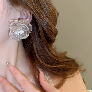Detail shot of sheer champagne gauze rose earrings with small pearls on model