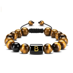 Macro detail of natural tiger eye and black onyx beads with golden letter B charm