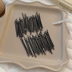 Lot de barrettes noires minimalistes sur plateau en céramique pour coiffure quotidienne