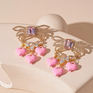 Detail of butterfly drop earring with pink zircon crystals and heart enamel pendants