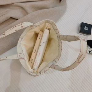 Quilted off-white canvas tote bag with red embroidery pattern and spacious interior