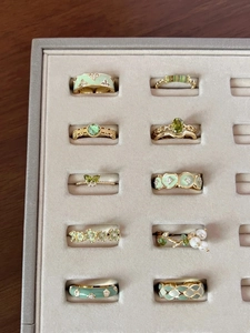 Detailed set of 10 gold-plated rings with green enamel, butterfly zircons, and pearls