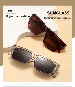Close-up of stylish rectangle sunglasses with golden V-shaped metal accents and tinted lenses
