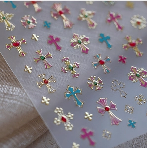 Macro detail of Baroque gold nail stickers with colorful gemstone cross patterns