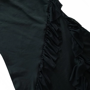 Detail view of ruffle trim and side slit texture on a black summer bodycon dress