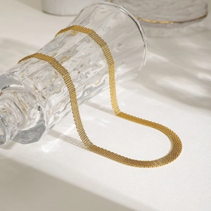 Collier élégant en maille d'acier inoxydable plaqué or 18 carats sur un verre