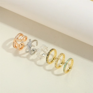 Detail view of gold and silver vintage V-shaped rings with zircon and enamel patterns